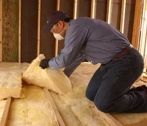 man installing fiberglass batt insulation