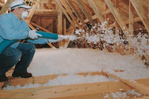 Blown-In fiberglass insulation being installed in an unfinished attic.