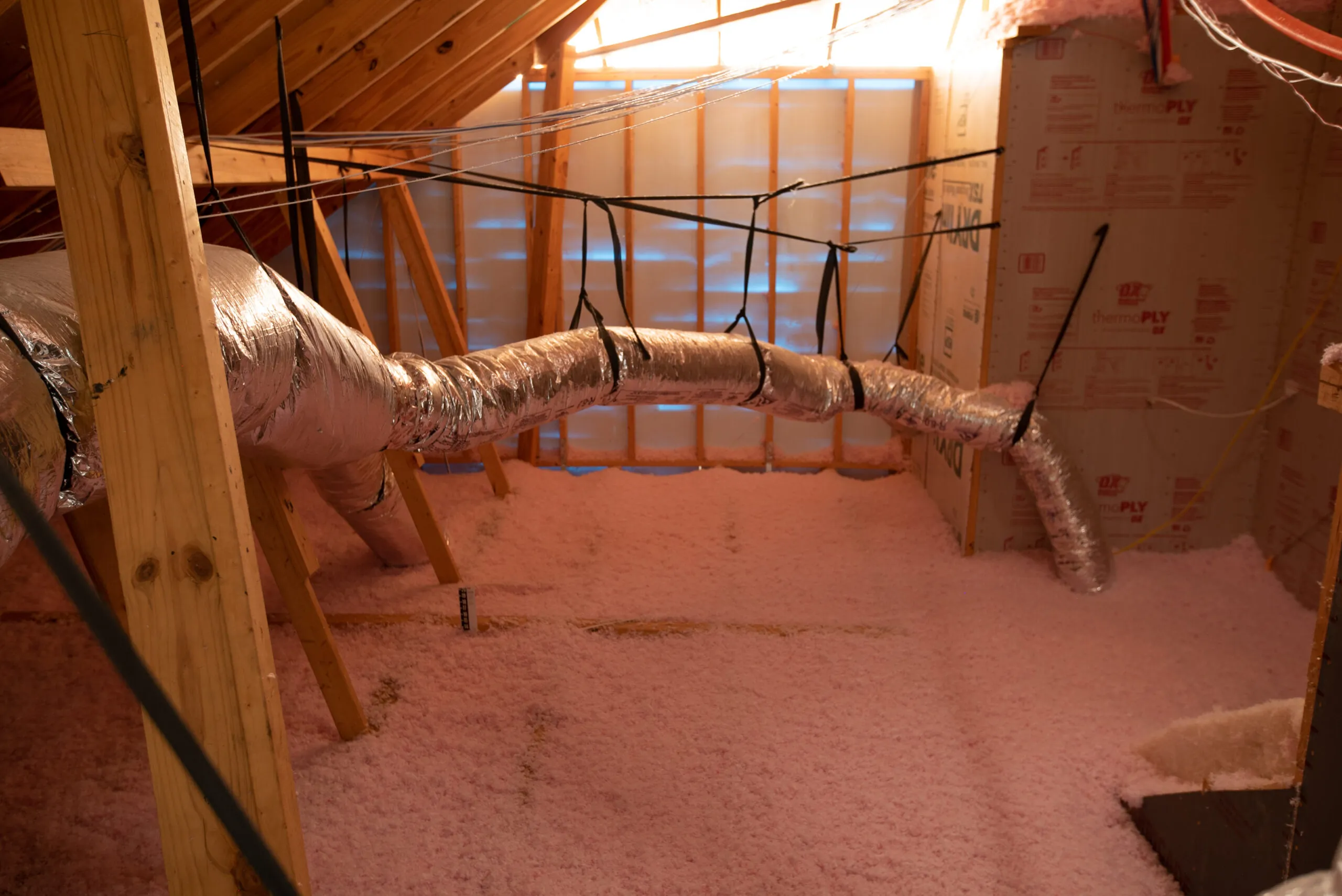 Blown-in pink fiberglass insulation in an attic